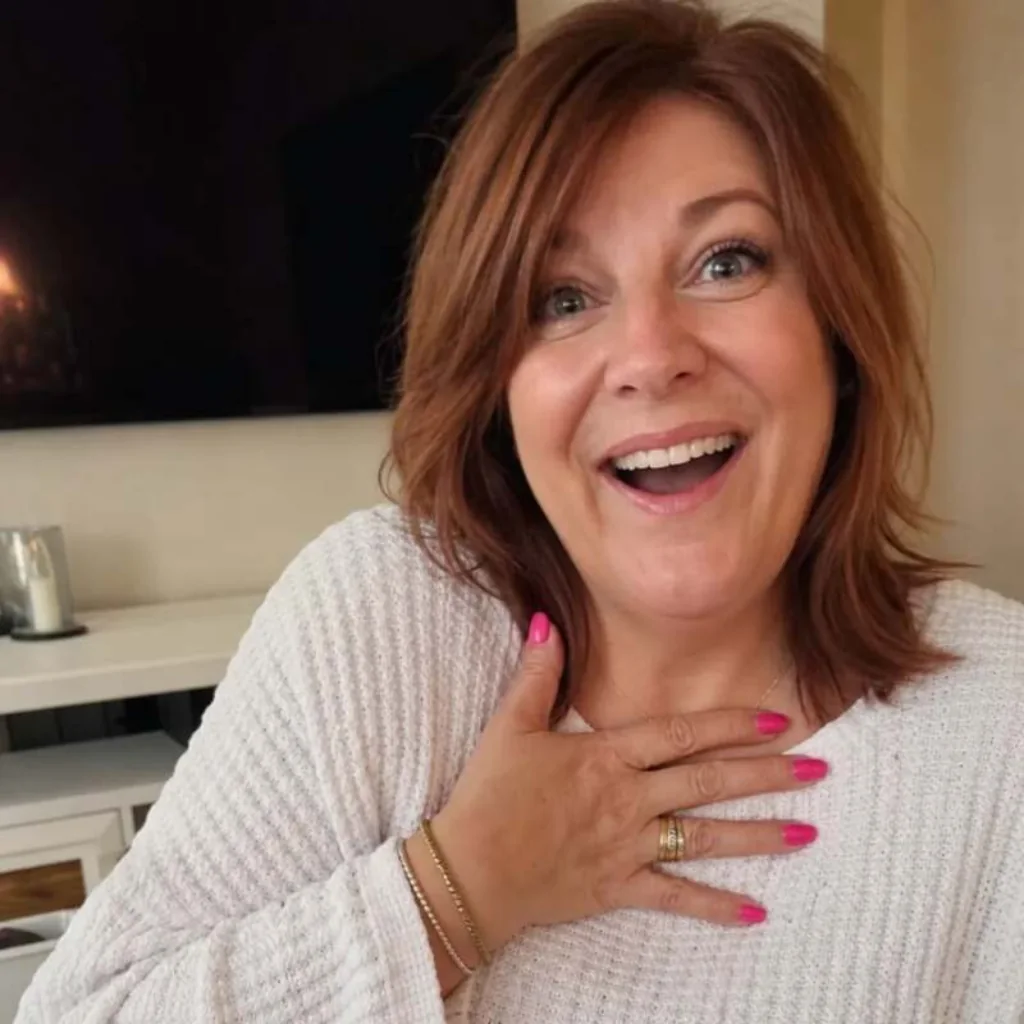 Vrouw glimlacht verrast met een hand op haar borst